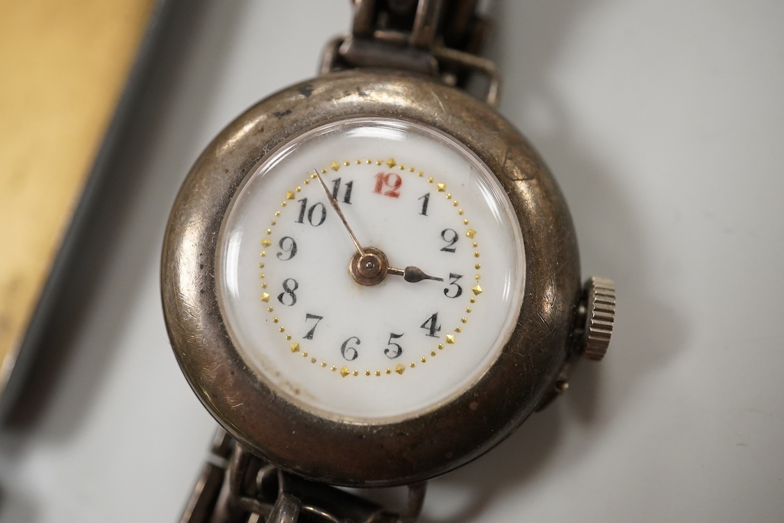 A collection of small silver to include a cigarette case, two napkin rings, three pairs of sugar tongs, a thimble, a lady's wrist watch and a mounted glass toilet jar. together with a 925 fob watch, a 935 mounted lighter